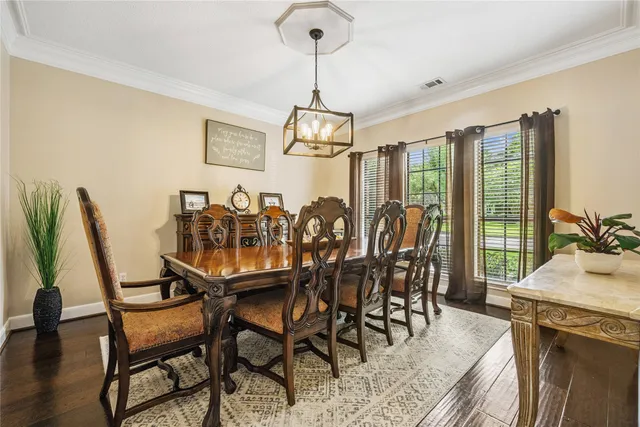 a dining room with furniture a chandelier and wooden floor