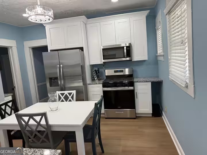 1230 Woodland Avenue Southeast Atlanta, GA 30316 - Photo 7 of 17 a kitchen with stainless steel appliances granite countertop a kitchen island a stove a table and chairs in it