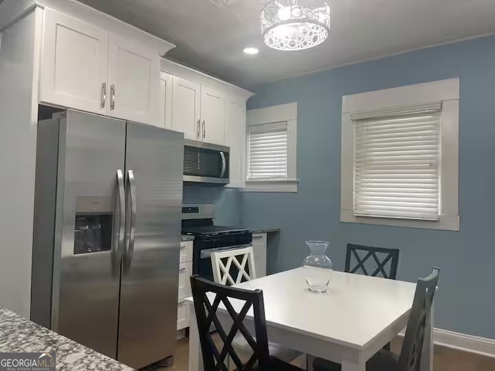 1230 Woodland Avenue Southeast Atlanta, GA 30316 - Photo 9 of 17 a kitchen with stainless steel appliances granite countertop a refrigerator a sink a stove a table and chairs