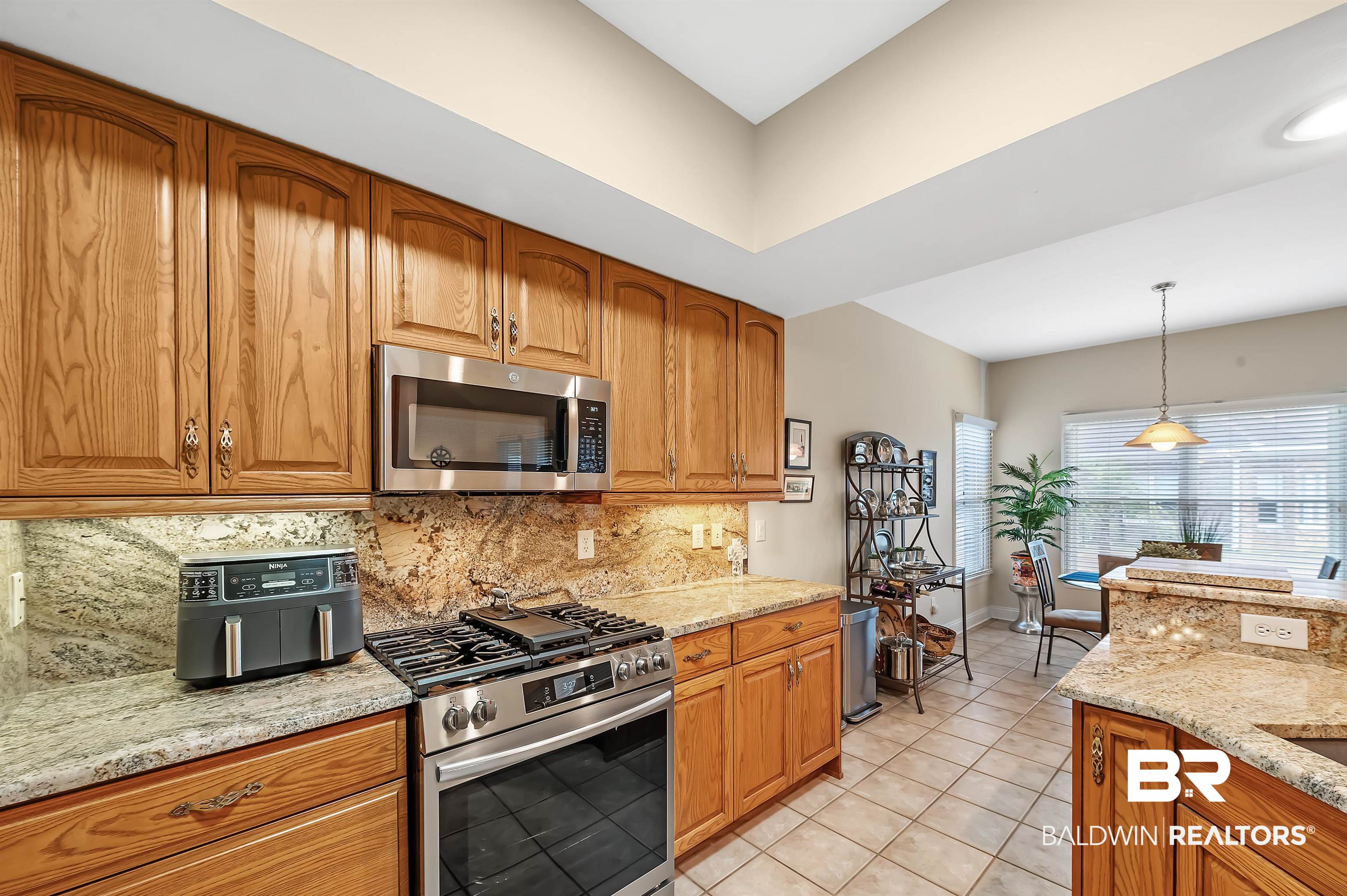 22726 Inverness Way Foley, AL 36535 - Photo 24 of 51 Kitchen featuring stainless steel appliances, tasteful backsplash, light stone counters, decorative light fixtures, and light tile patterned flooring