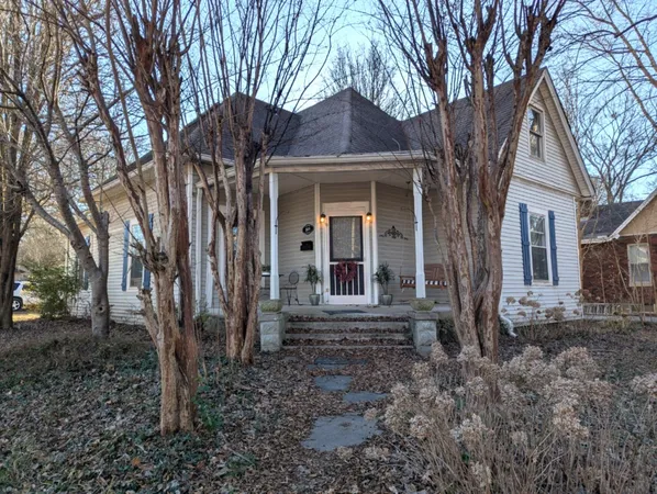 a view of a house with a yard and large tree