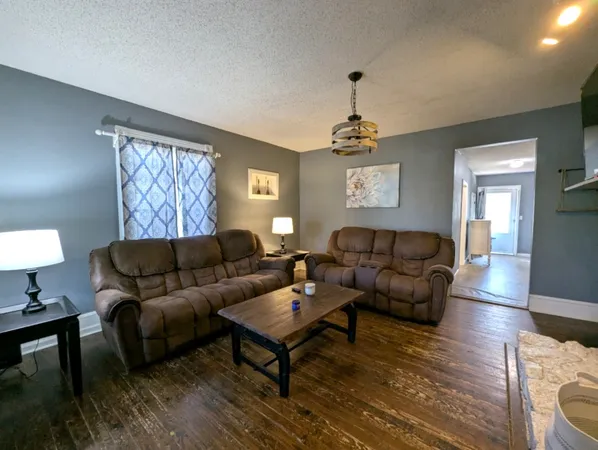 a living room with furniture a lamp and a window