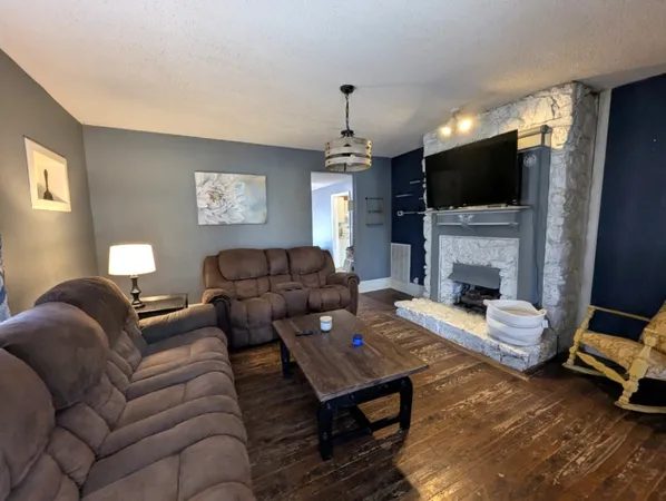 a living room with furniture a flat screen tv and a fireplace