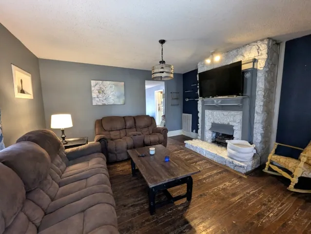 a living room with furniture a flat screen tv and a fireplace