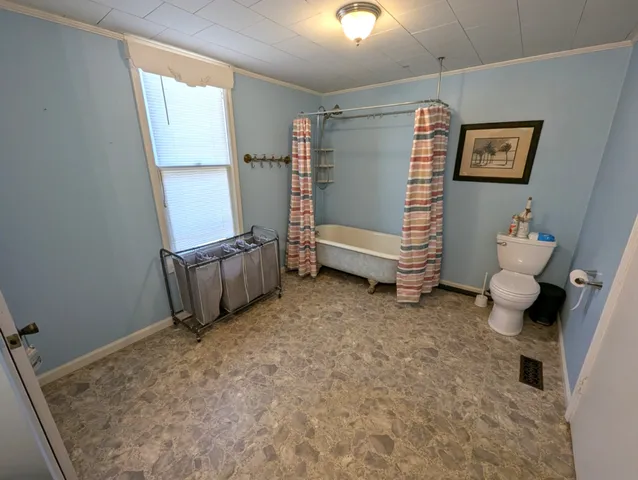 a view of an empty room with stairs and a window