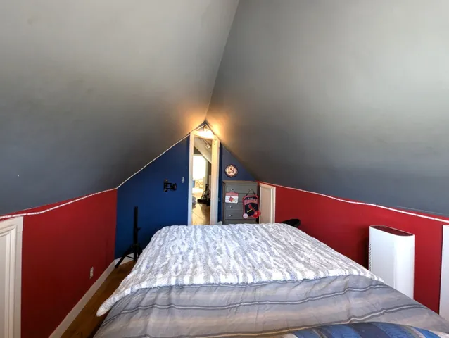 a bed sitting in a bedroom next to a window