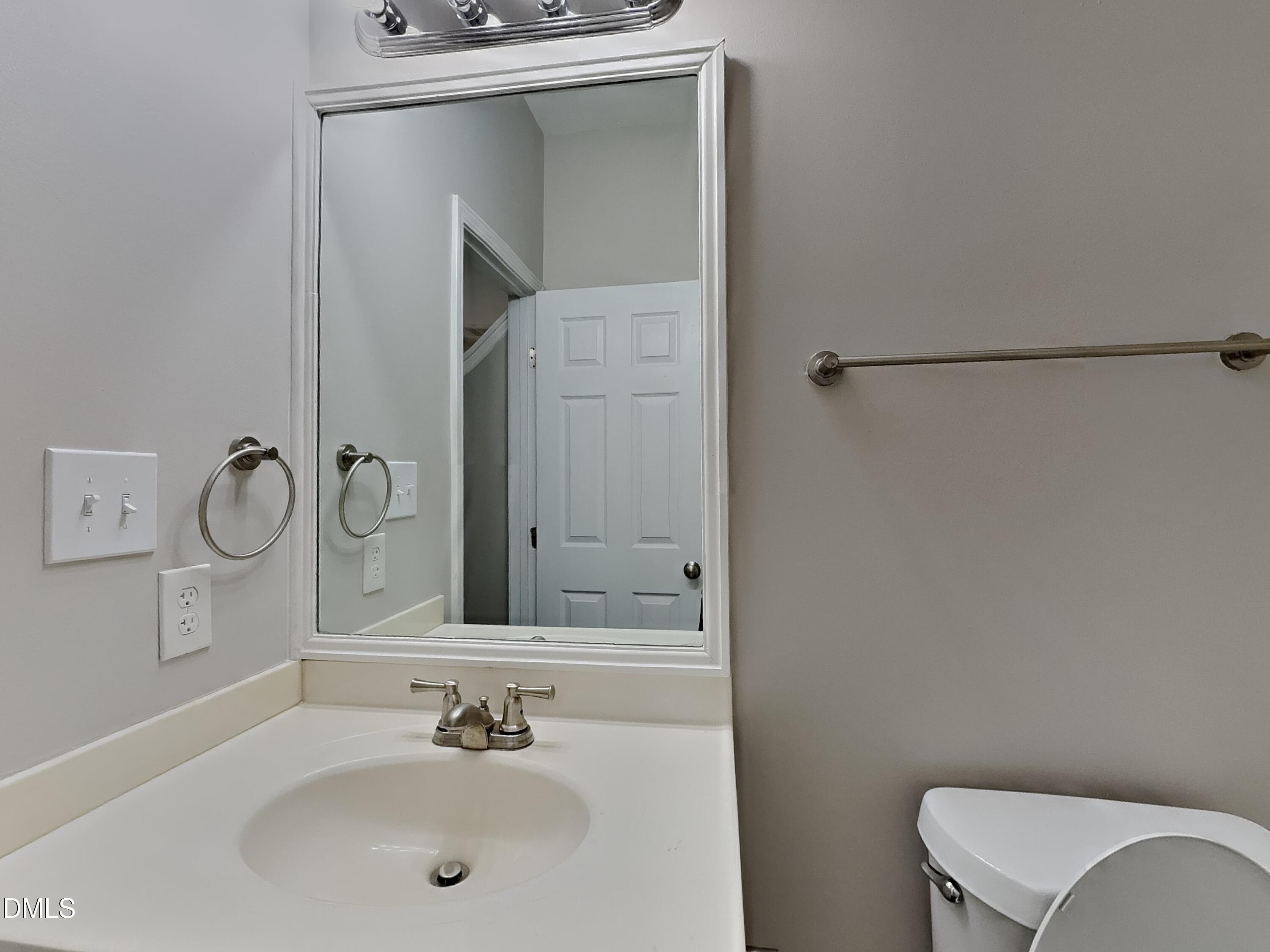 5816 Wynmore Road Raleigh, NC 27610 - Photo 14 of 18 a bathroom with a sink and a mirror