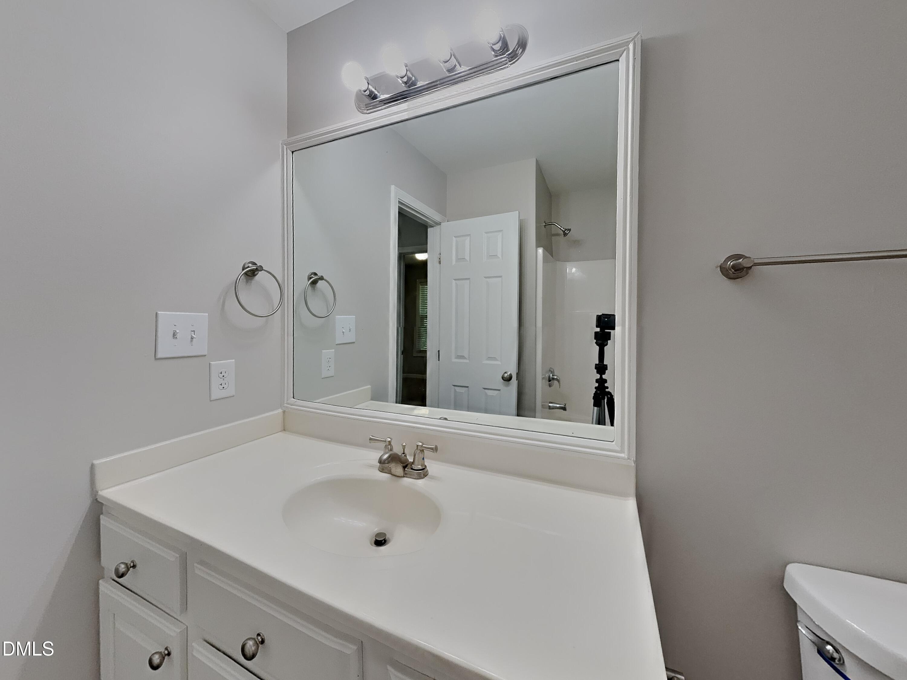 5816 Wynmore Road Raleigh, NC 27610 - Photo 16 of 18 a bathroom with a sink and a mirror