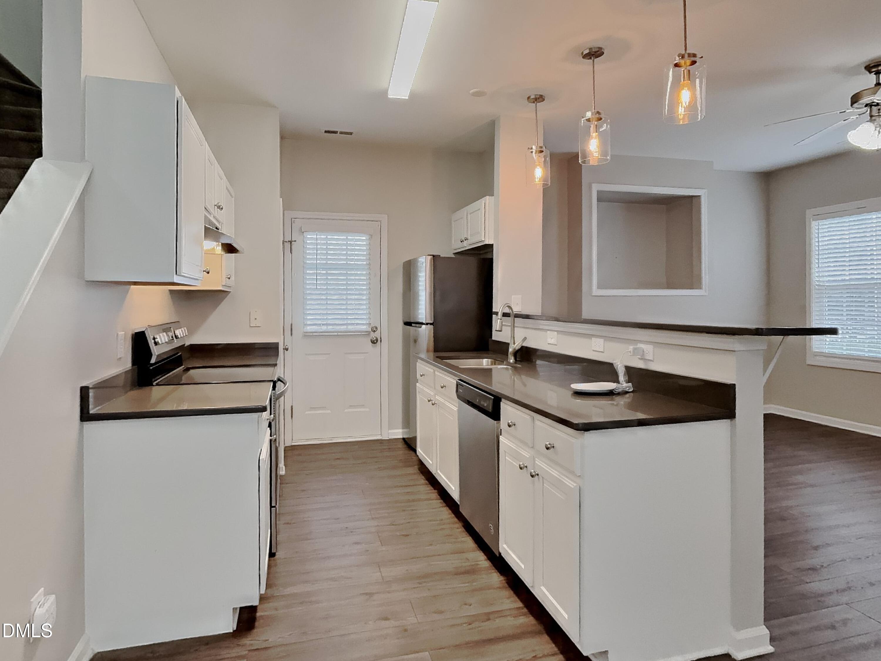 5816 Wynmore Road Raleigh, NC 27610 - Photo 5 of 18 a kitchen with stainless steel appliances granite countertop a stove and a sink