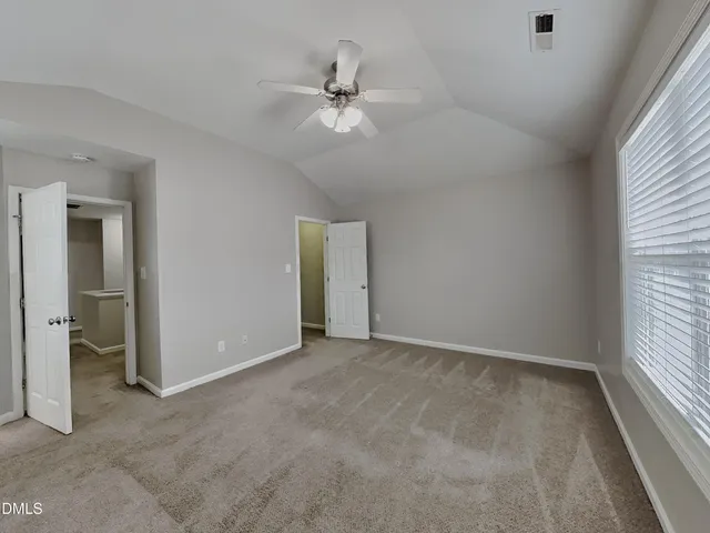 an empty room with fan and windows