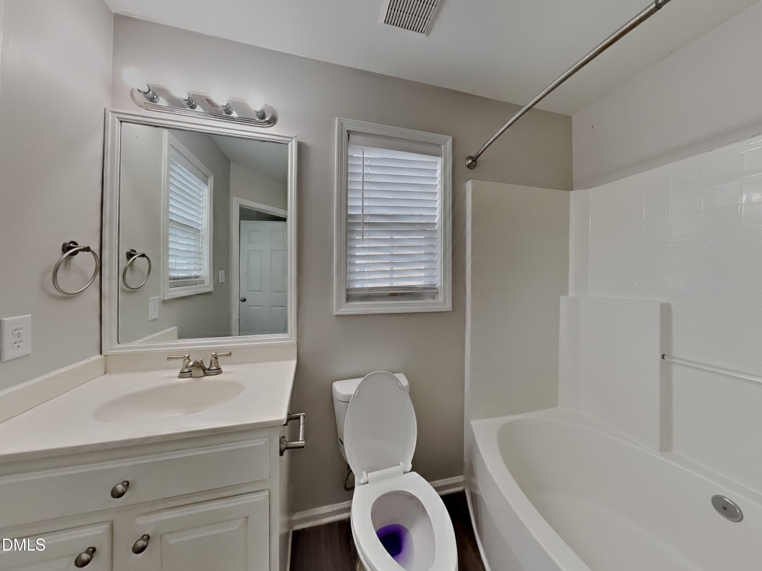 5816 Wynmore Road Raleigh, NC 27610 - Photo 9 of 18 a bathroom with a granite countertop sink toilet a mirror and bathtub