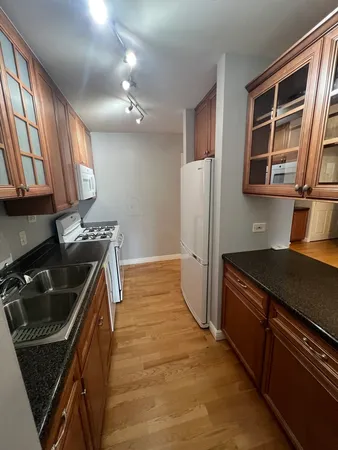 a kitchen that has a sink wooden cabinets and stainless steel appliances