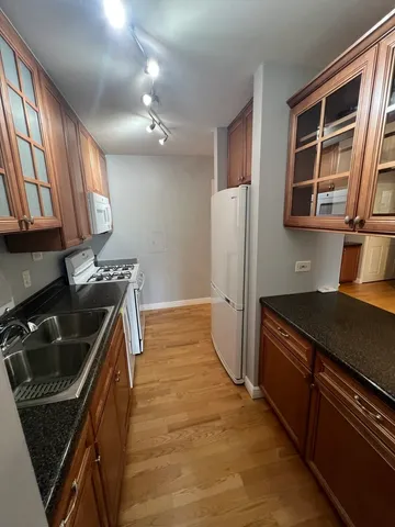 a kitchen that has a sink wooden cabinets and stainless steel appliances