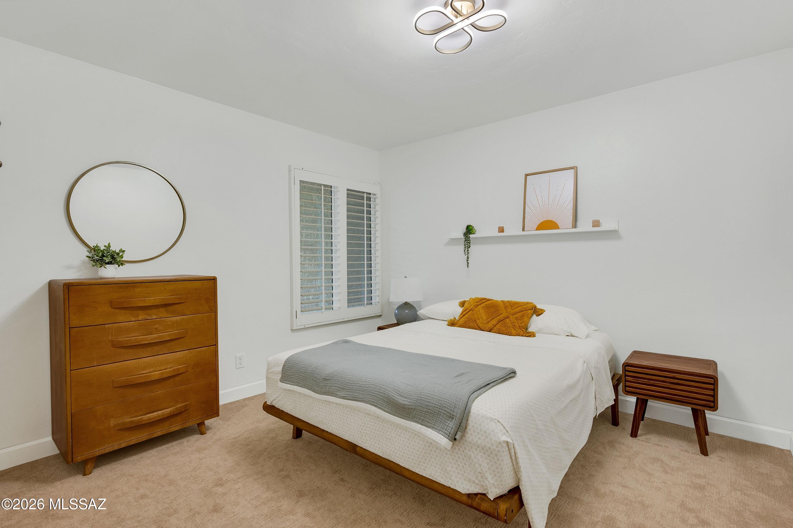 6941 East Rivercrest Road Tucson, AZ 85750 - Photo 17 of 32 a bedroom with a bed lamp and a window
