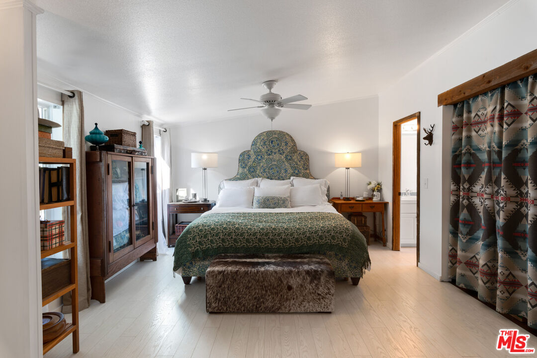 29500 Heathercliff Road, Unit 53 Malibu, CA 90265 - Photo 13 of 24 a spacious bedroom with a large bed and a chandelier