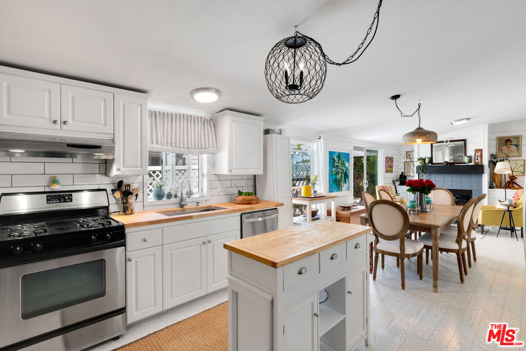29500 Heathercliff Road, Unit 53 Malibu, CA 90265 - Photo 8 of 24 a kitchen with a stove cabinets and dining table chair