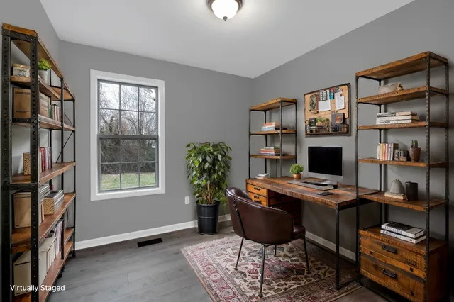 a view of a workspace with furniture and a window