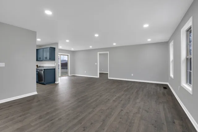 an empty room with wooden floor and a fireplace