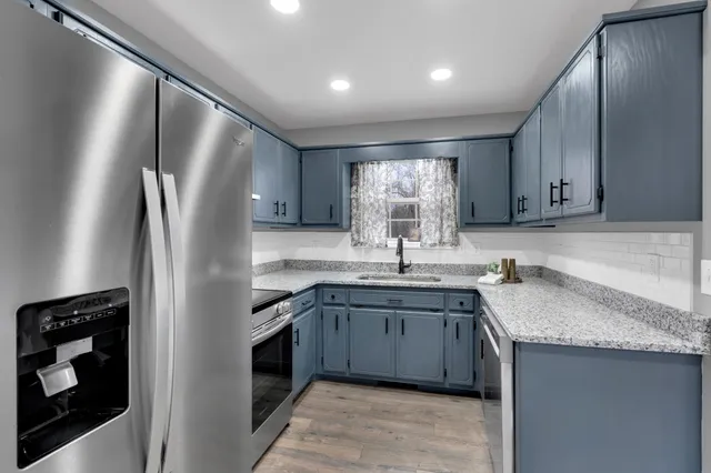 a kitchen with stainless steel appliances granite countertop a sink stove and refrigerator