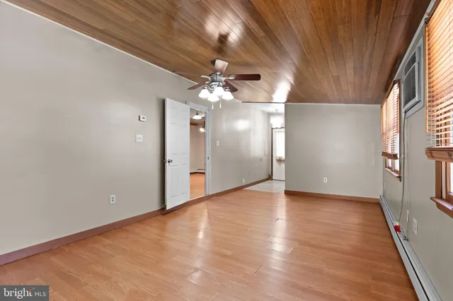 an empty room with fan and windows