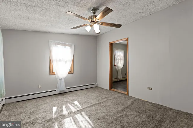 a view of an empty room with glass door and a window