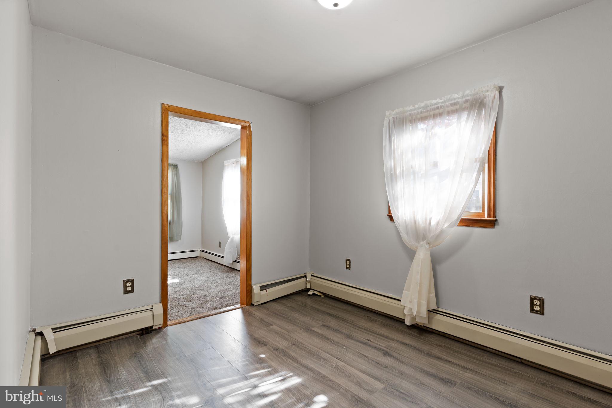 212 Plumbridge Drive Levittown, PA 19056 - Photo 10 of 19 an empty room with wooden floor mirror and windows