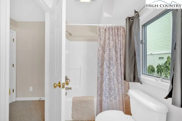 a bathroom with a toilet and a shower