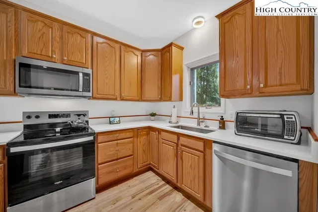 a kitchen with granite countertop wooden cabinets stainless steel appliances and a window