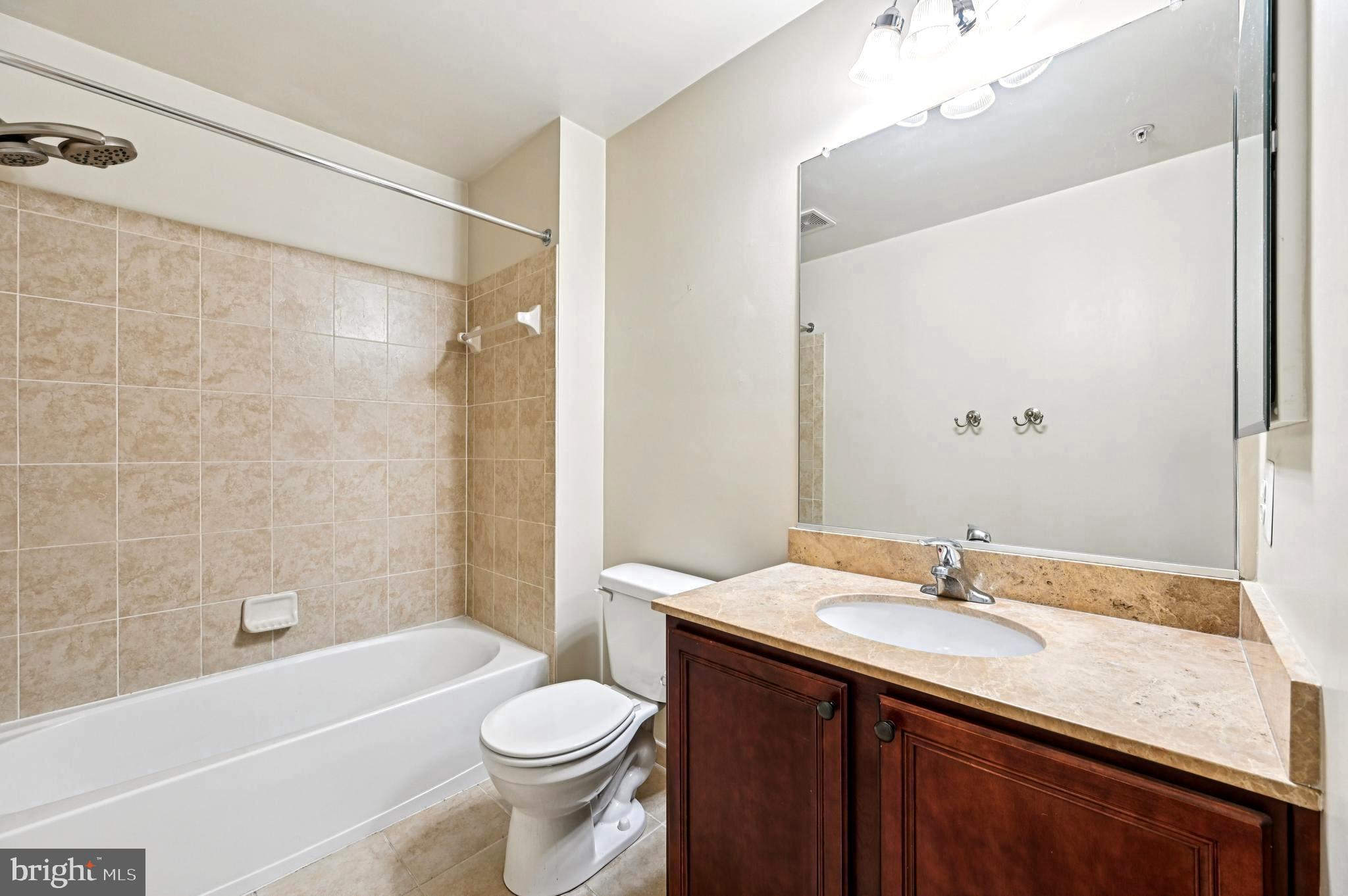 6467 Cornwall Drive, Unit 56 Eldersburg, MD 21784 - Photo 20 of 35 a bathroom with a sink a toilet a mirror a bathtub and shower