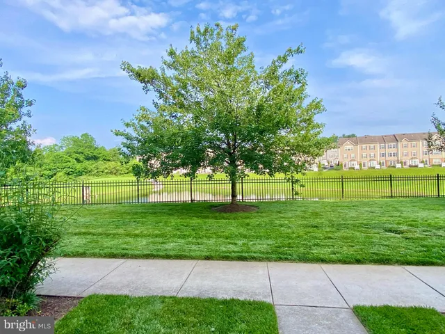 a green field with lots of trees in the background