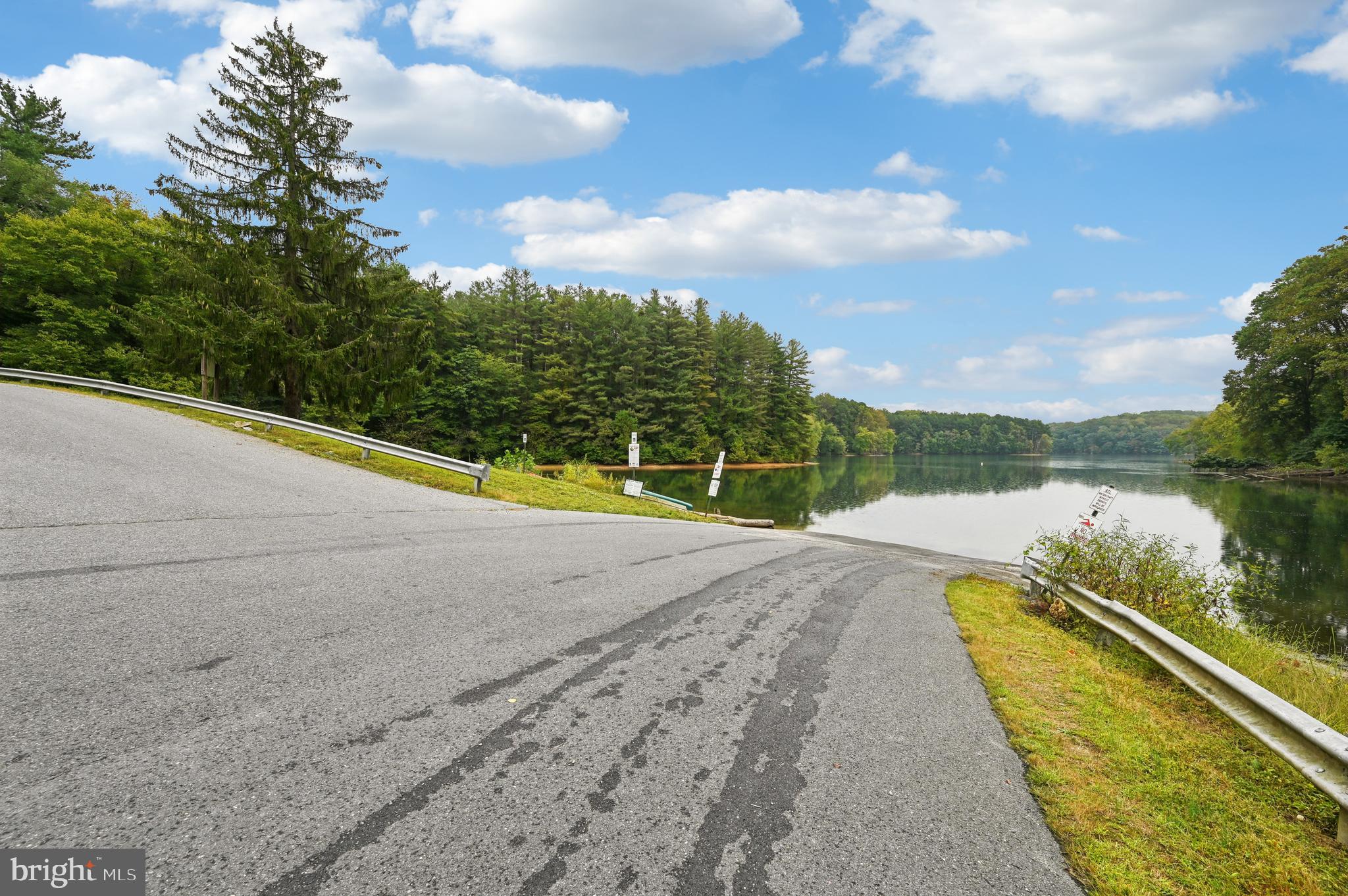 6467 Cornwall Drive, Unit 56 Eldersburg, MD 21784 - Photo 32 of 35 a view of swimming pool with a lake and trees in the background