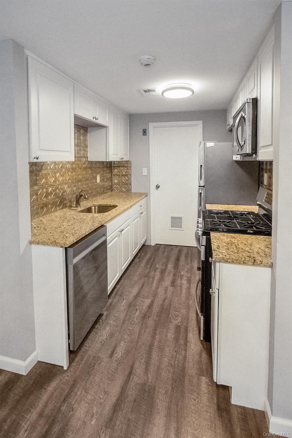 100 Glen Hollow Drive Port Jefferson Station, NY 11776 - Photo 3 of 21 a kitchen with a sink stove and cabinets
