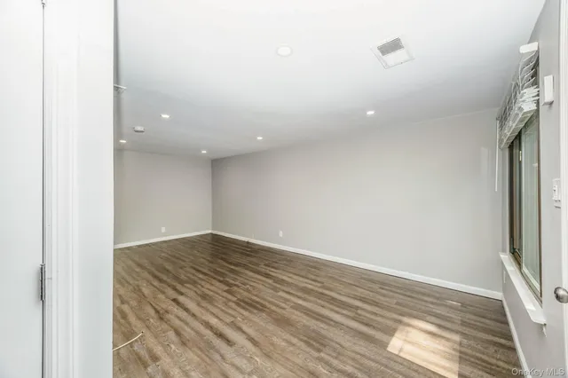 a view of room with wooden floor and windows
