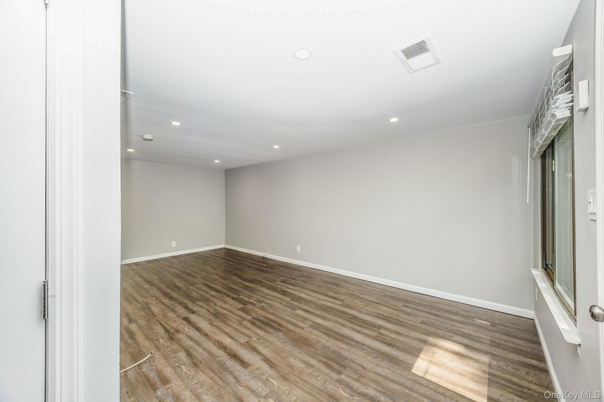 100 Glen Hollow Drive Port Jefferson Station, NY 11776 - Photo 5 of 21 a view of an empty room with wooden floor and a window