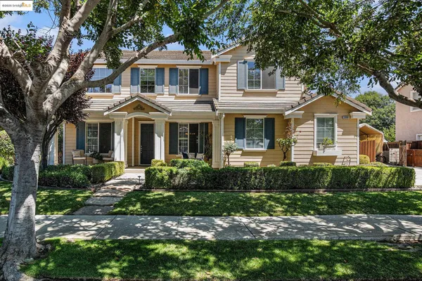 a front view of a house with a yard and potted plants
