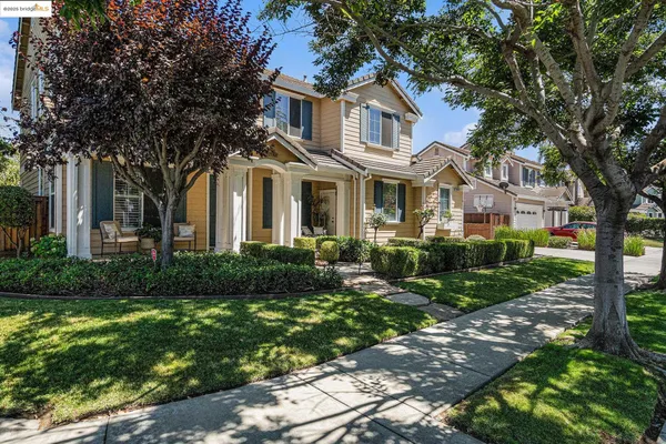 a front view of a house with a yard and trees