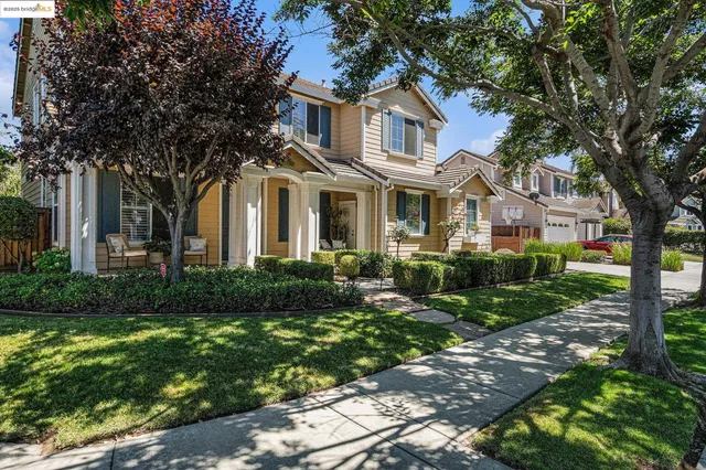 a front view of a house with a yard and trees
