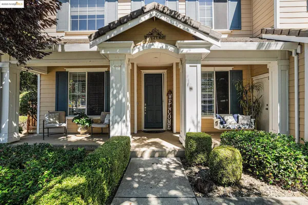 a view of a house with large windows and flower plants