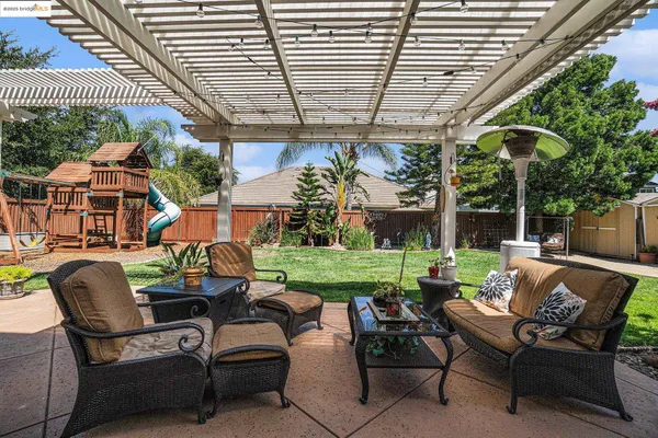a view of a patio with table and chairs potted plants and a large tree