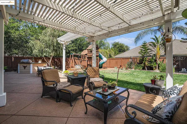 a view of a patio with table and chairs potted plants and palm trees