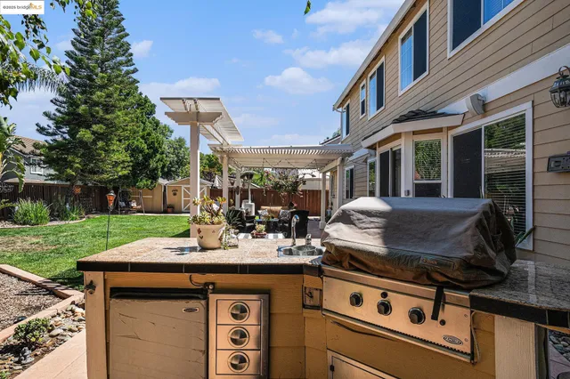a view of a chair and table in backyard of the house