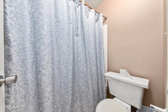 a white toilet sitting next to a shower curtain
