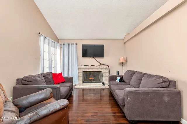 a living room with furniture a fireplace and a flat screen tv