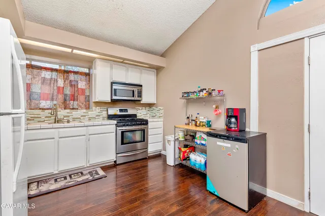 a kitchen with a sink cabinets and wooden floor
