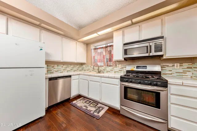 a kitchen with granite countertop wooden cabinets and stainless steel appliances