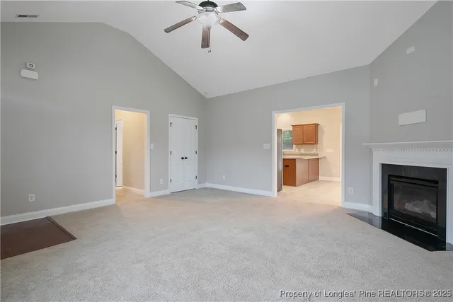 a view of empty room with a fireplace and fan