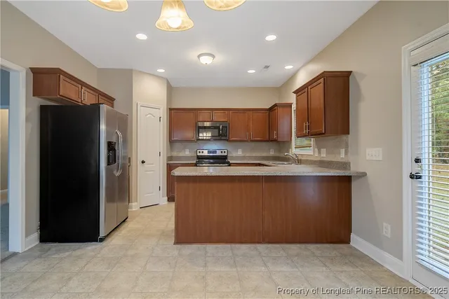 a kitchen with stainless steel appliances granite countertop a refrigerator and a sink