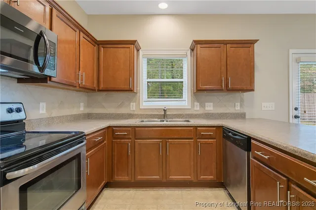 a kitchen with stainless steel appliances granite countertop a sink stove and microwave