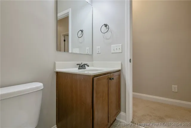 a bathroom with a sink a toilet and mirror