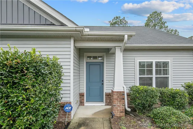 a front view of a house with plants
